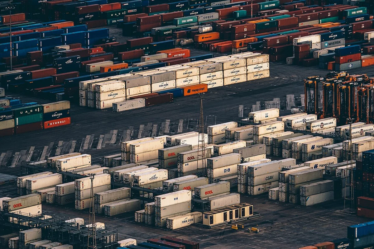 Stacked shipping containers at a port terminal — congestion ties up vessel capacity and keeps China to US freight rates elevated after Golden Week 2026